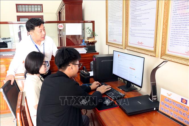 Thay vì các thủ tục giấy tờ, văn bản như trước kia, tại Trung tâm phục vụ Hành chính công xã Giao Ninh, người dân được hướng dẫn làm thủ tục hành chính trên trang dịch vụ hành chính công. (Ảnh: Nguyễn Lành/TTXVN)